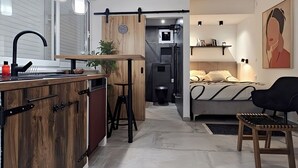 A modern kitchen with wooden cabinets, a black faucet, and pendant lights. - Apartments Marijana (Vodice)