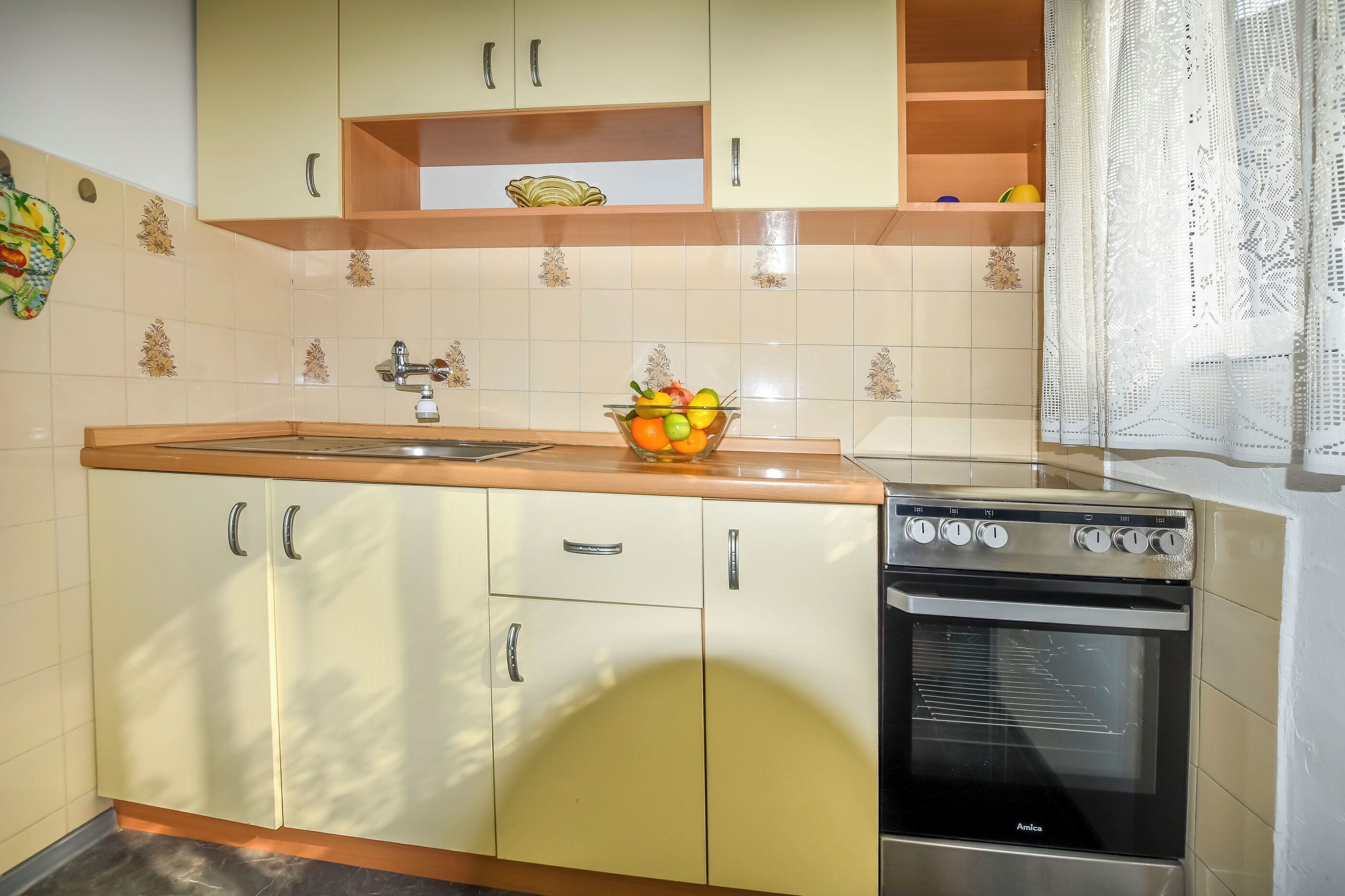 A kitchen with a sink, countertop, and oven.