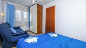 A room with a bed, a massage chair, a wardrobe, and a door. - Apartments Sopic (Rogoznica)