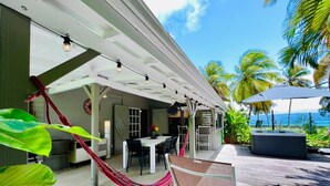 An outdoor patio with a table and chairs, a hammock, and a hot tub. -  Viva Villa Village down the Fort  (Gosier)