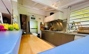 Prepare meals in the fully equipped kitchen with a refrigerator, oven, and stove, and enjoy the natural light from the large window.