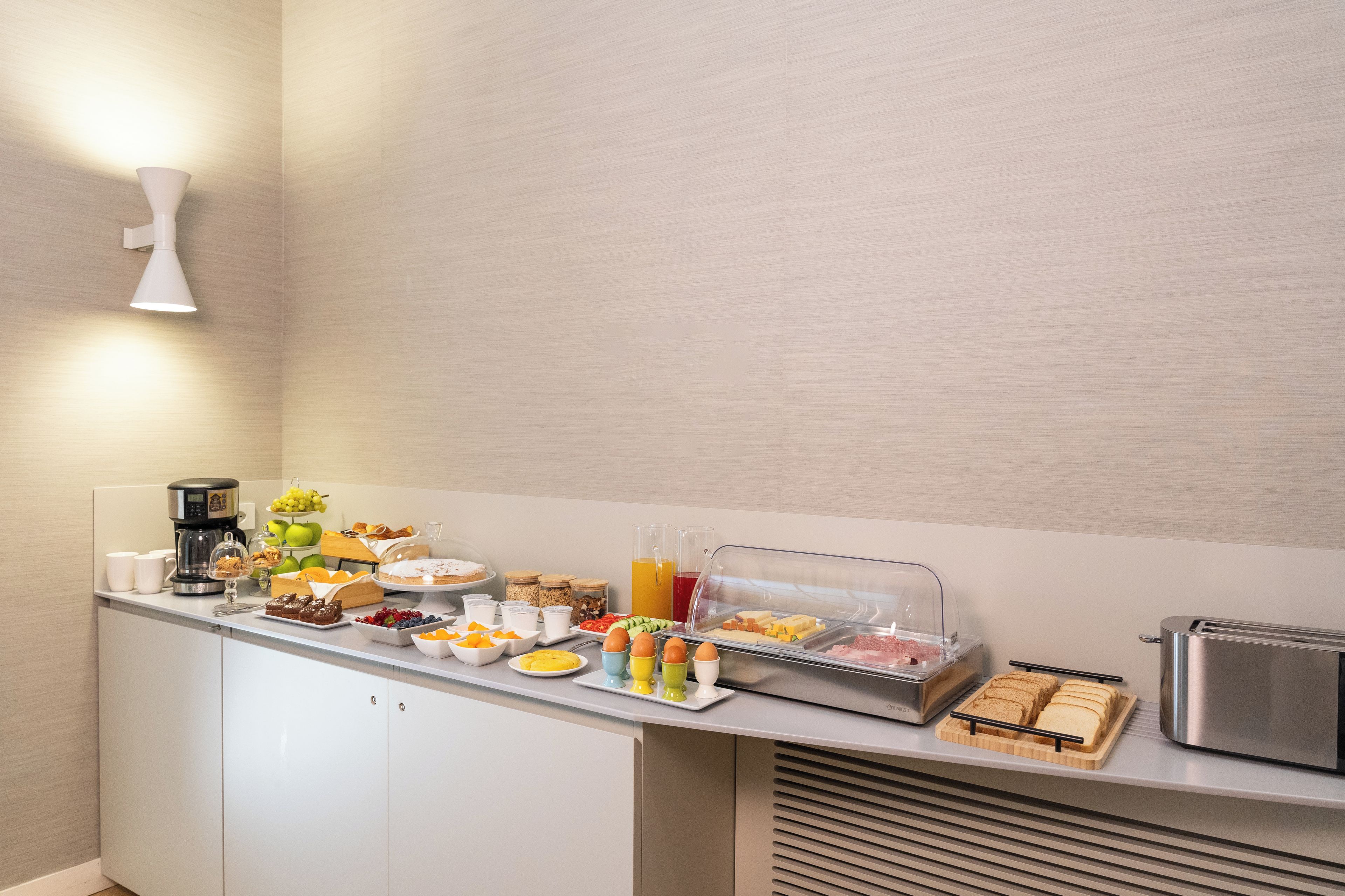 A breakfast buffet with various food items and a coffee maker.