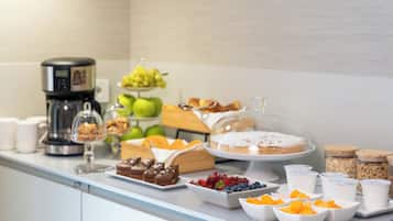 A buffet table with various food items and a coffee machine.