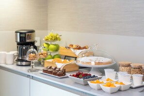 A buffet table with various food items and a coffee machine. - Laurina 33 (Rome)