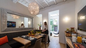 A modern dining area with a wooden table, black tablecloth, and a large mirror above it. - Laurina 33 (Rome)