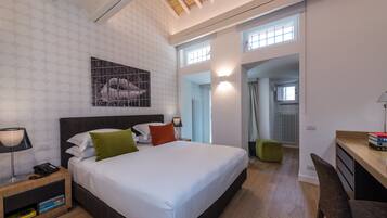 Un dormitorio moderno con una cama grande, un escritorio y vistas a la cocina.