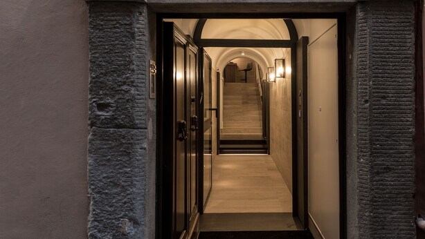 A stone-arched entrance to a hallway with a number 33 sign above it. - Laurina 33 (Rome)
