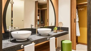 Une salle de bain avec deux lavabos, un grand miroir et un meuble-lavabo en bois.