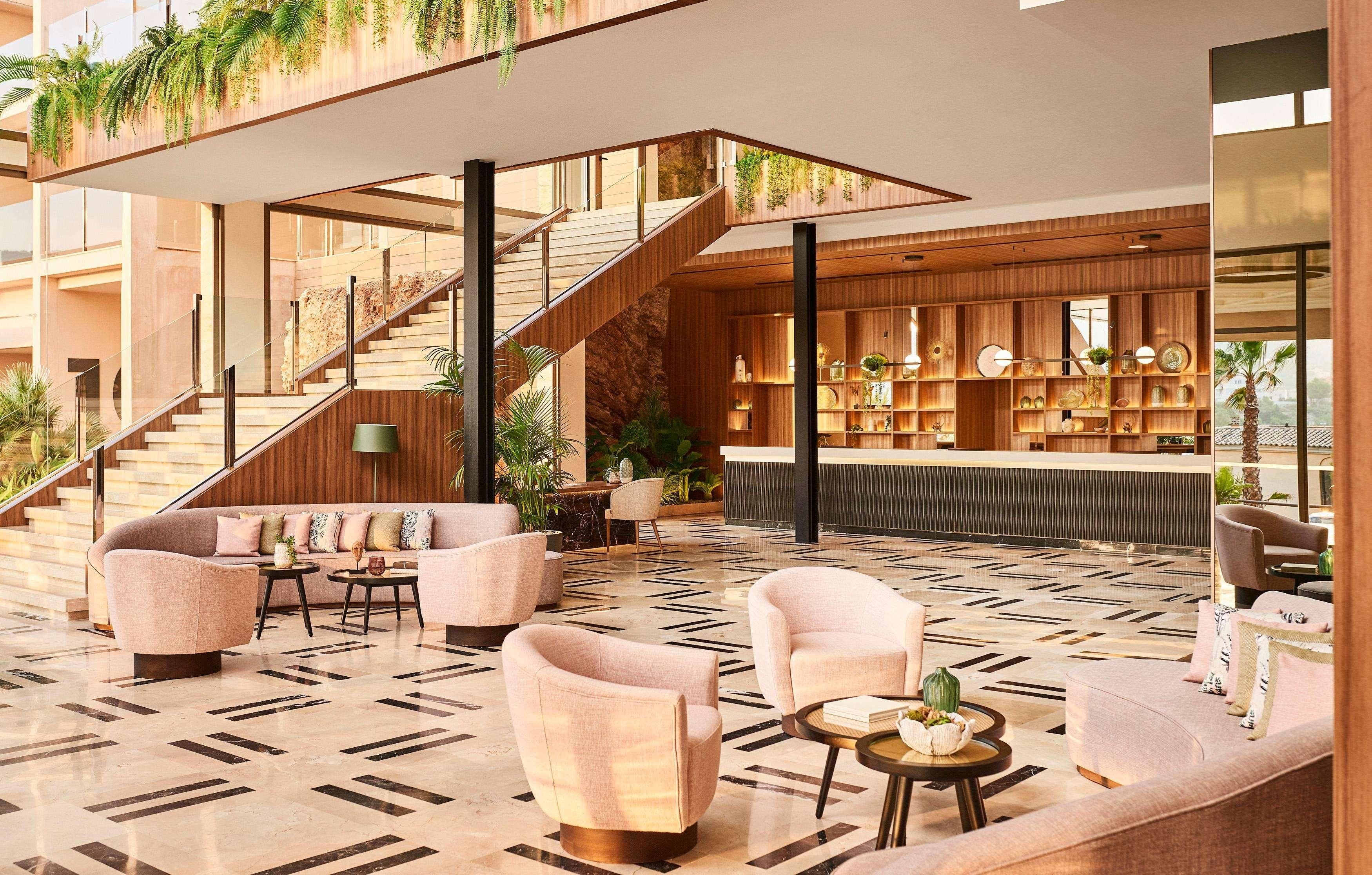 A modern lobby with a staircase, seating area, and a bar.