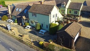 Une rangée de maisons traditionnelles, avec un petit espace de stationnement devant.