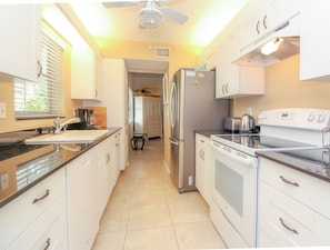 Enjoy cooking and dining in this well-lit kitchen with a sleek layout and ample workspace.