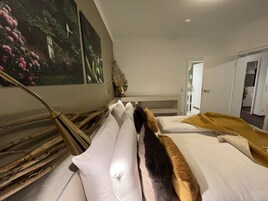 Una habitación de hotel con cama, mesita de noche, lámpara y un cuadro en la pared.