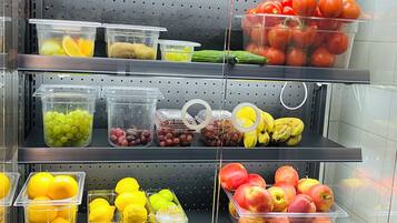 A refrigerated display of various fruits and vegetables in a grocery store.