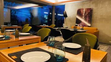Ein Restaurant mit gedeckten Tischen, Stühlen und einem großen Fenster mit Blick.