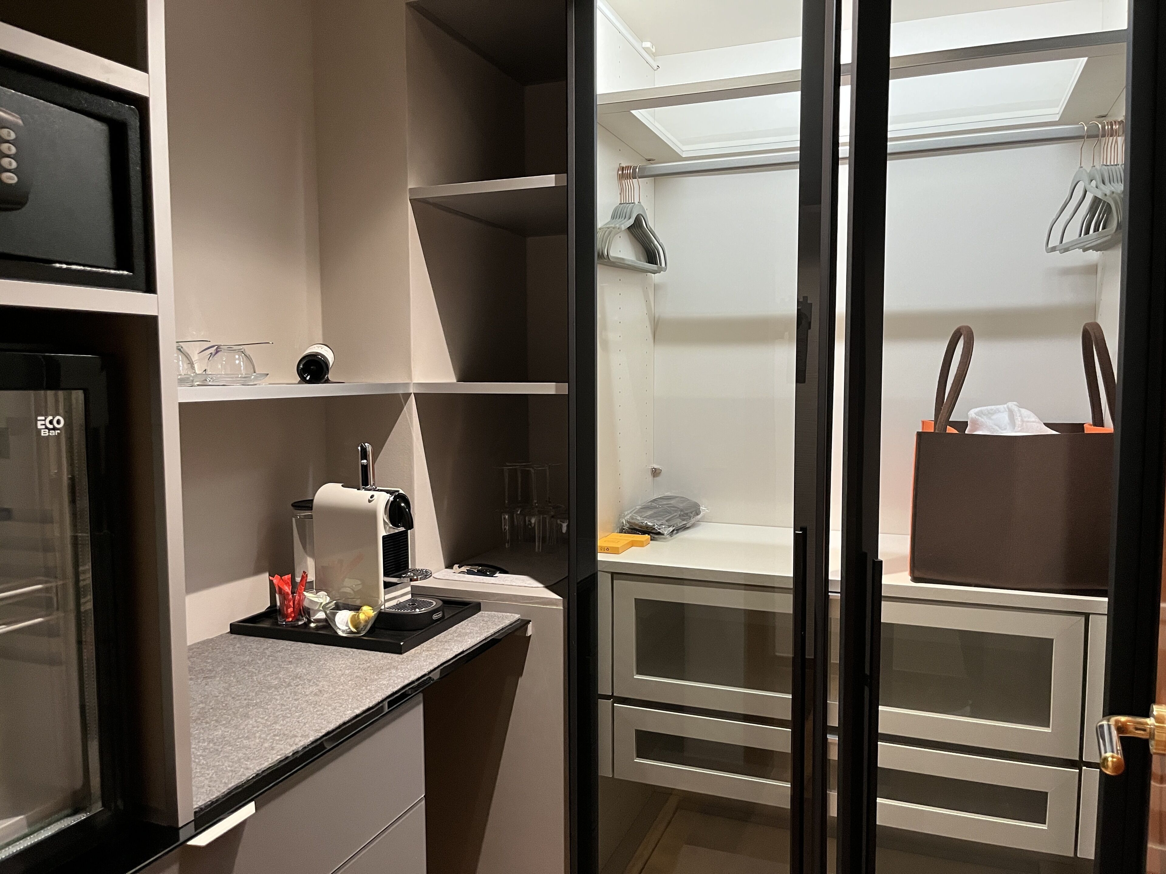 A compact kitchenette with a coffee machine, a small sink, and a countertop.