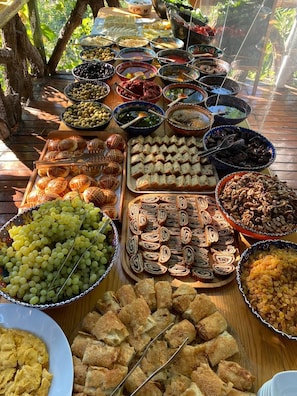 A table with various food items including grapes, bread rolls, and pastries. - Turan Hill Lounge (Fethiye)