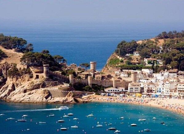 Overlooking the sea, this coastal town features a mix of traditional and modern architecture, with a historic fortification on a rocky outcrop.