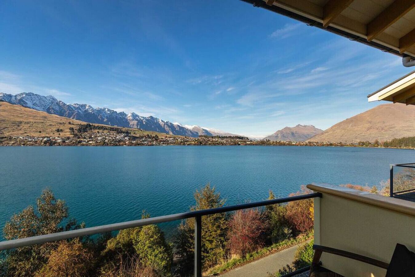 Vista al lago desde un balcón, con montañas al fondo.