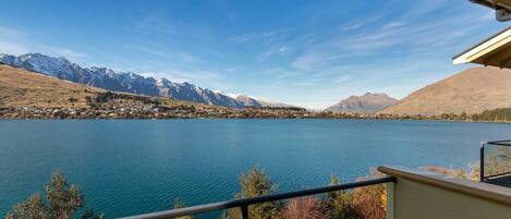 Vista al lago desde un balcón, con montañas al fondo.
