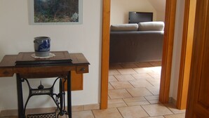 Una habitació amb una taula de fusta, una màquina de cosir i un quadre al mur.