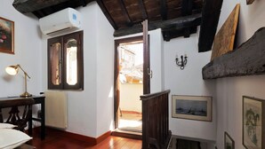 Een kamer met houten vloeren, een radiator, een houten deur en een raam.
