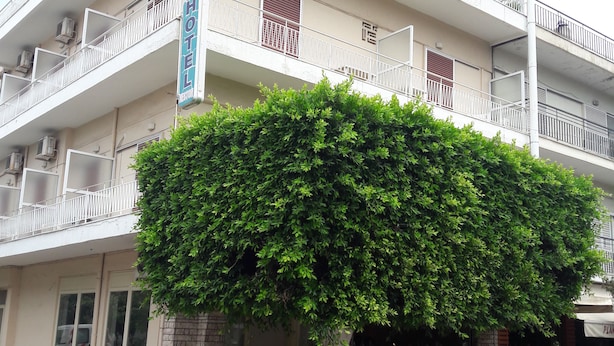 A multi-story hotel with balconies, air conditioning units, and a sign indicating it is a hotel. - Nestor (Zacharo)