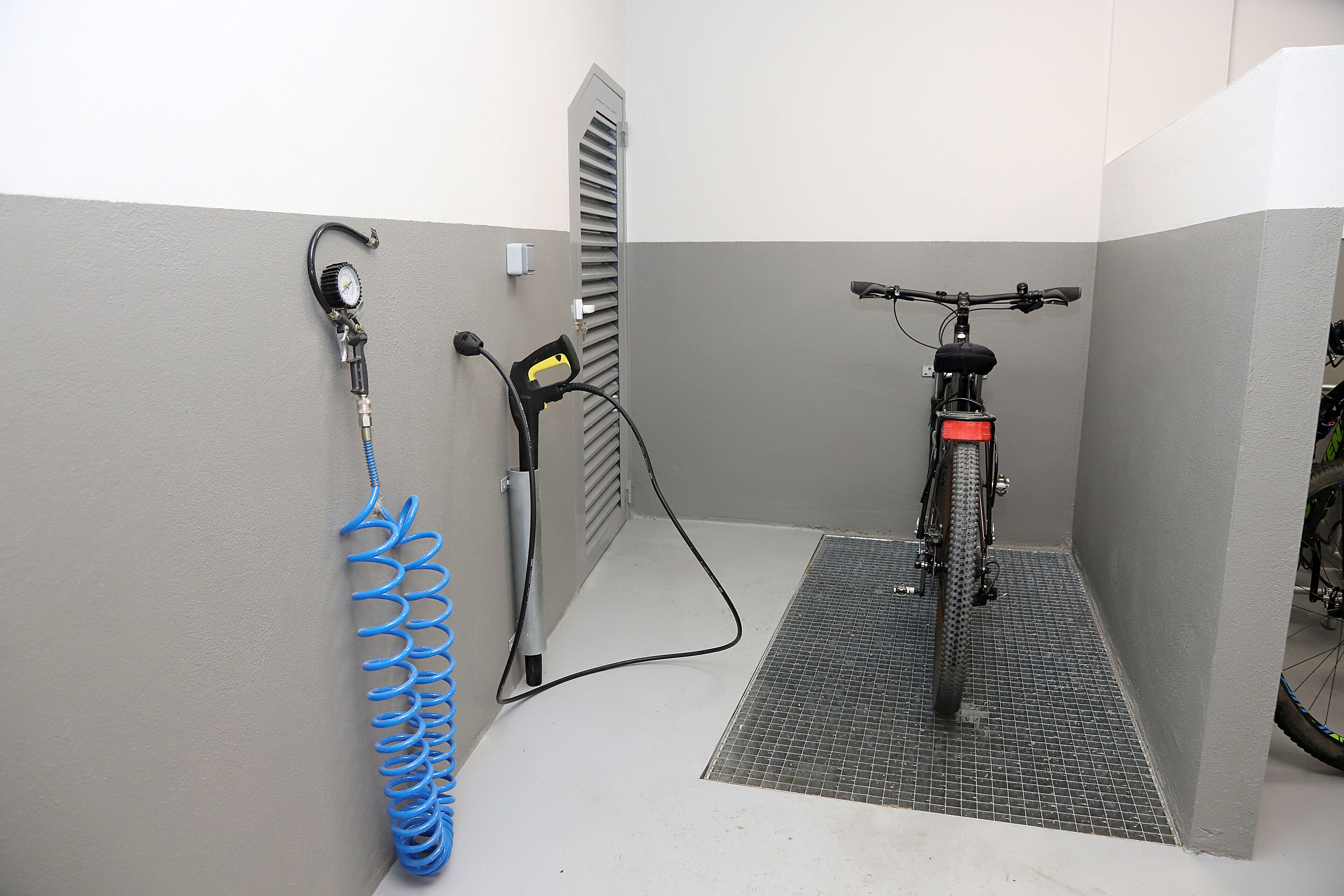 A bicycle repair station with a pressure pump and a bike stand.