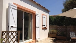 A house with a tiled patio, a wooden fence, and a clear sky.