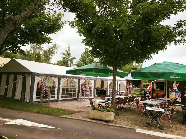 Una hilera de carpas con toldos verdes, probablemente para comidas al aire libre o eventos.