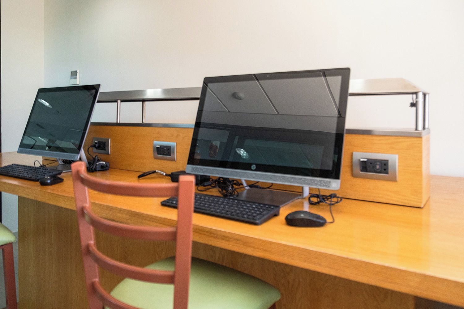 A workspace with two desktop computers, a keyboard, a mouse, and a chair.