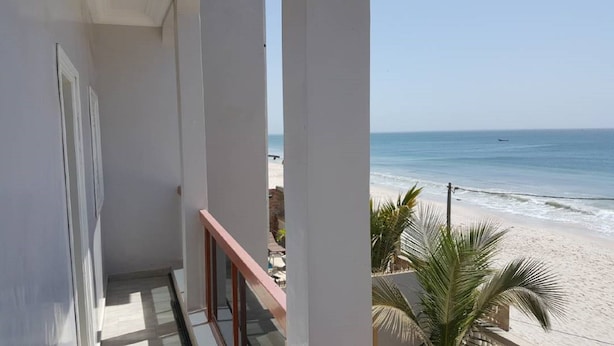 En balkon med udsigt over strand og hav.