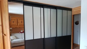 Une pièce dotée d’une porte coulissante, d’un canapé et d’une armoire en bois.