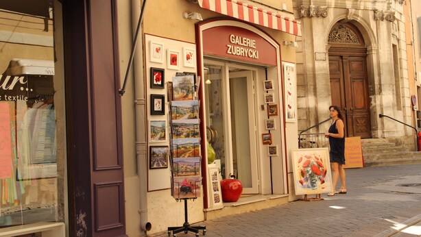 Una botiga amb un rètol que diu "GALERIE ZUBRYCKI" i diverses obres d'art exposades a l'exterior.