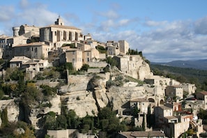Une ville historique construite sur une colline, avec des bâtiments en pierre et une tour imposante.