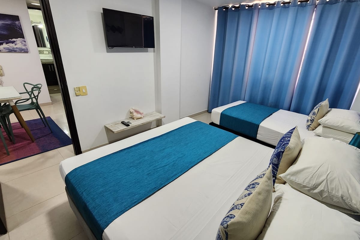 Habitación de hotel con dos camas, un escritorio y una silla.