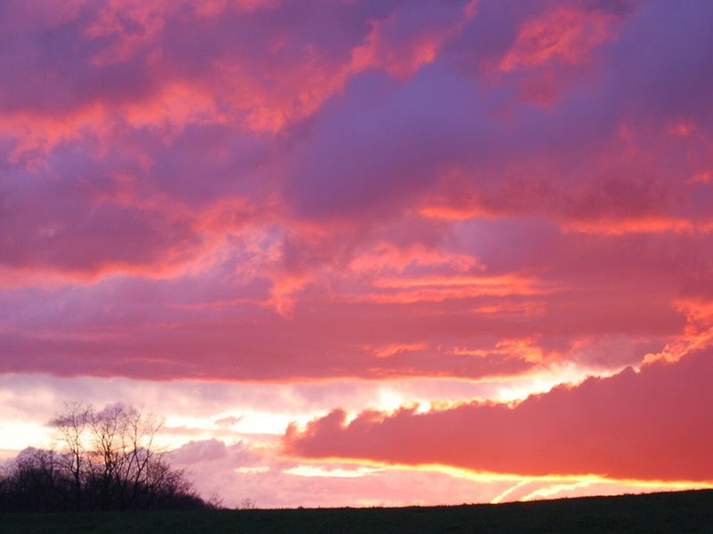 Ein Sonnenuntergang über einer ebenen Landschaft mit scharfem Horizont.