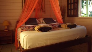 A bed with a canopy, pillows, and a bedside table with a lamp.