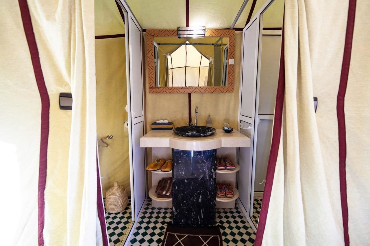A compact bathroom with a sink, mirror, and shelves for shoes.