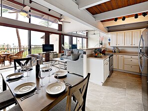 A spacious kitchen with a dining area, large windows, and a view of the outdoors.