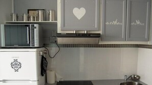 Una cocina con microondas, refrigerador y lavamanos.
