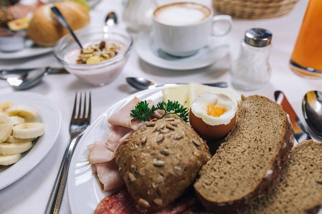 A breakfast setting with bread, eggs, and bananas on a table.