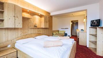 Una habitación de madera con una cama, un escritorio y un televisor.
