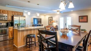 A modern kitchen with wooden cabinets, stainless steel appliances, and a central island with bar stools.