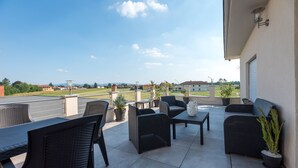 A terrace with outdoor furniture, potted plants, and a view of the surrounding area. - La Montrucca camere (Caselle Torinese)