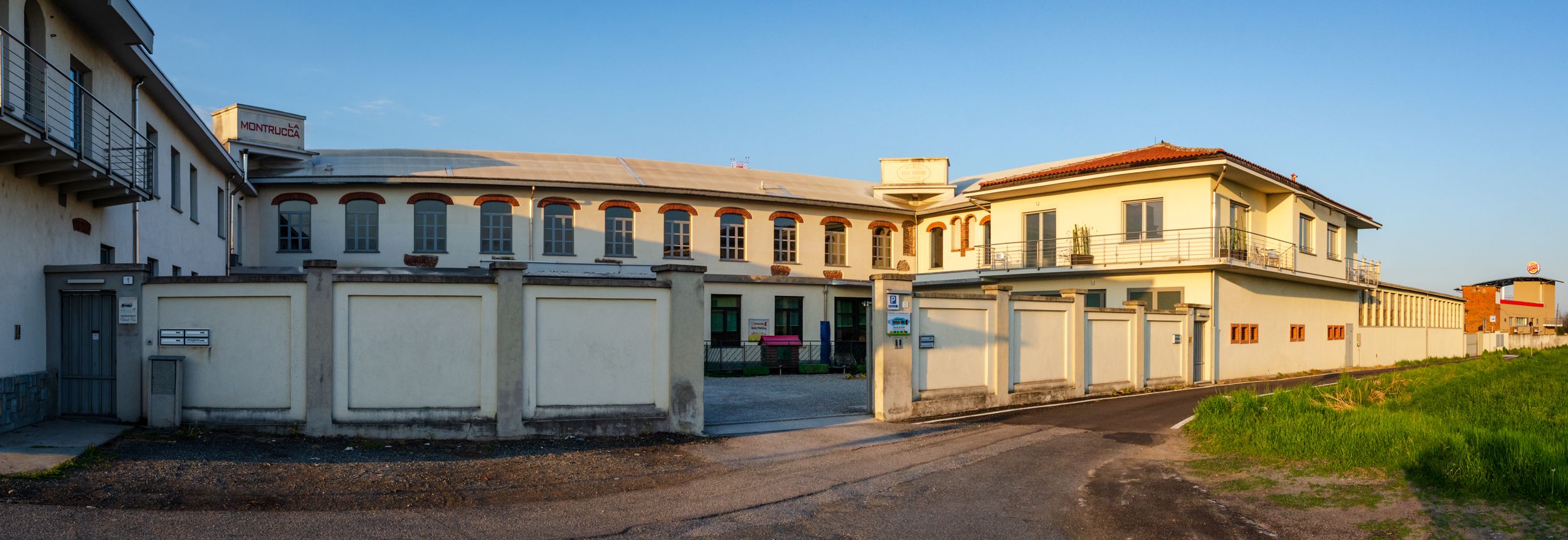 A building with a curved facade, large windows, and a gated entrance.