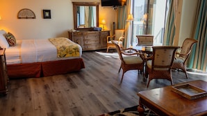 A hotel room with a bed, a desk, chairs, a dresser, and a TV. - Pool & close to Beaches, Elegant King Bed Studio (Sleeps 4) FREE Parking! (Honolulu)