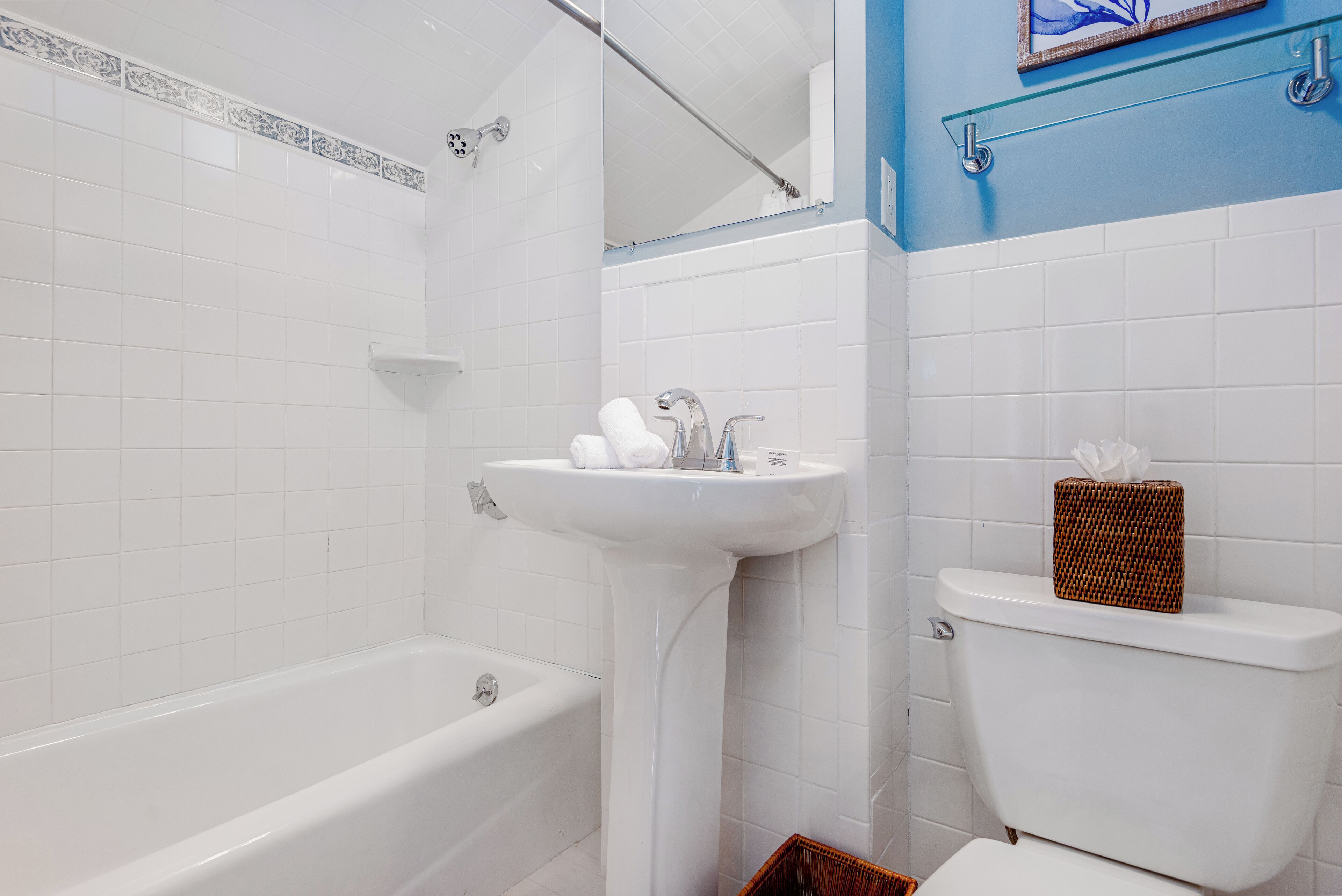 Un baño con una bañera blanca, un lavamanos blanco y un inodoro.