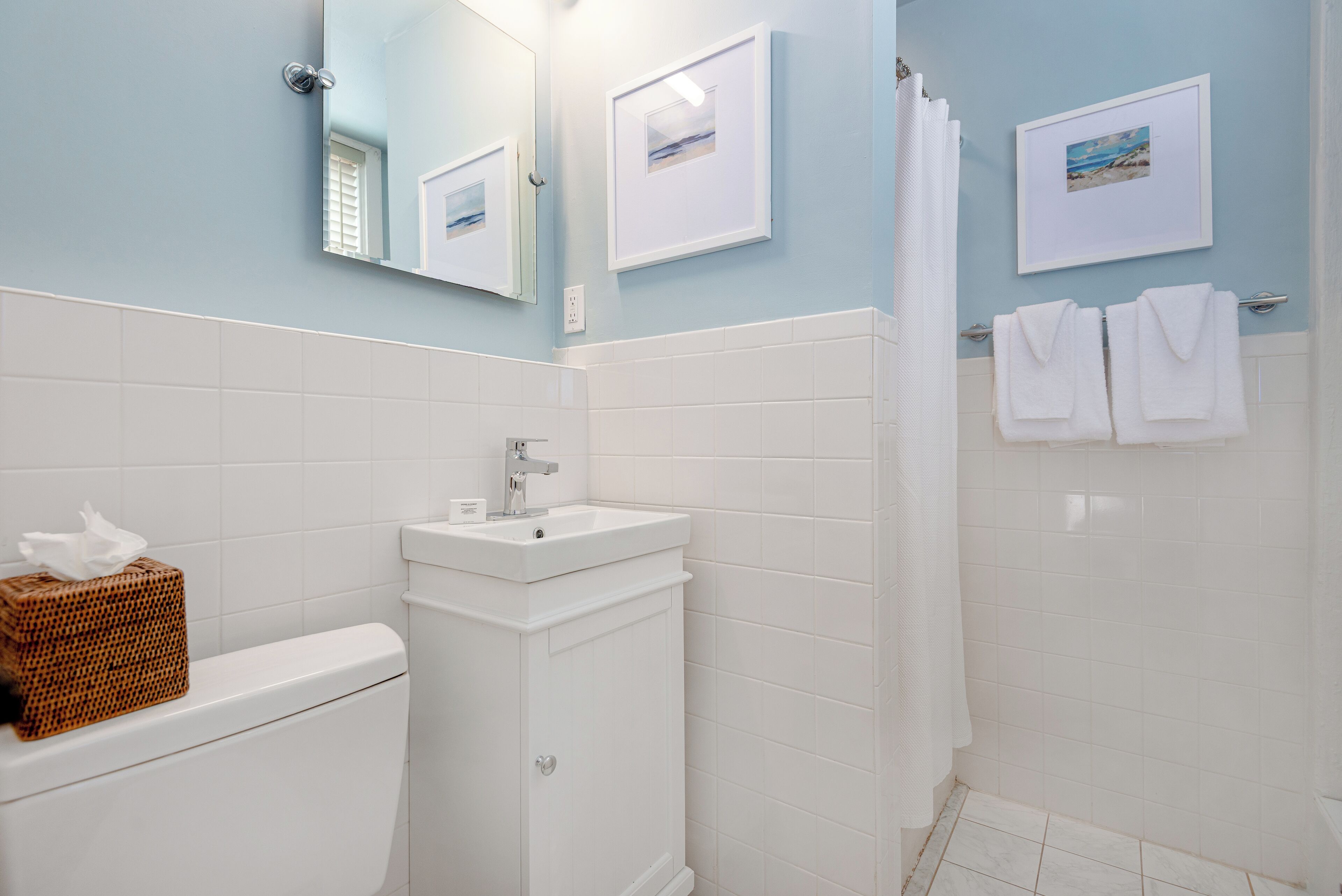 Une salle de bain équipée de toilettes, d’un lavabo et d’un porte-serviettes.