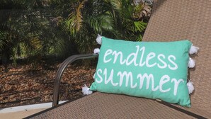 Un fauteuil de relaxation avec un coussin orné de l’inscription « été sans fin ».
