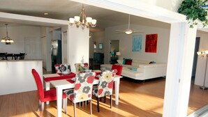 A spacious living area with a dining table and chairs, a white sofa, and a chandelier. - Lauras Paradise (Rotonda West)